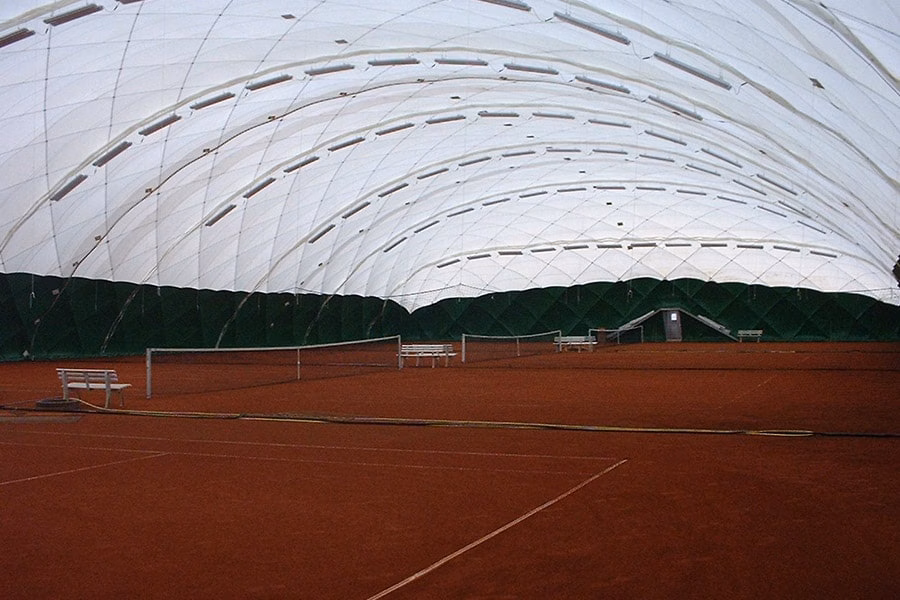 Paranet Nutzungskonzept Tennis Traglufthalle 3 Mehrere Rotsand-Tennisplätze unter der hohen Bogenkonstruktion einer PARANET Traglufthalle.