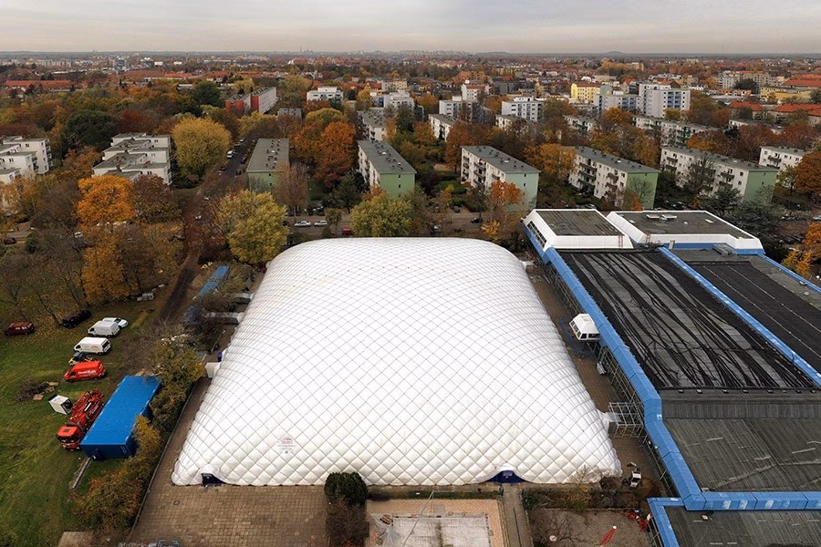 Paranet Traglufthalle Galerie 2 Luftaufnahme einer großen quadratischen Traglufthalle neben einem Gebäude in einem Wohngebiet im Herbst.