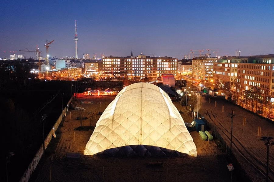 Paranet Traglufthalle Galerie 6 Beleuchtete PARANET Traglufthalle bei Nacht mit Blick auf die Berliner Skyline und den Fernsehturm im Hintergrund.
