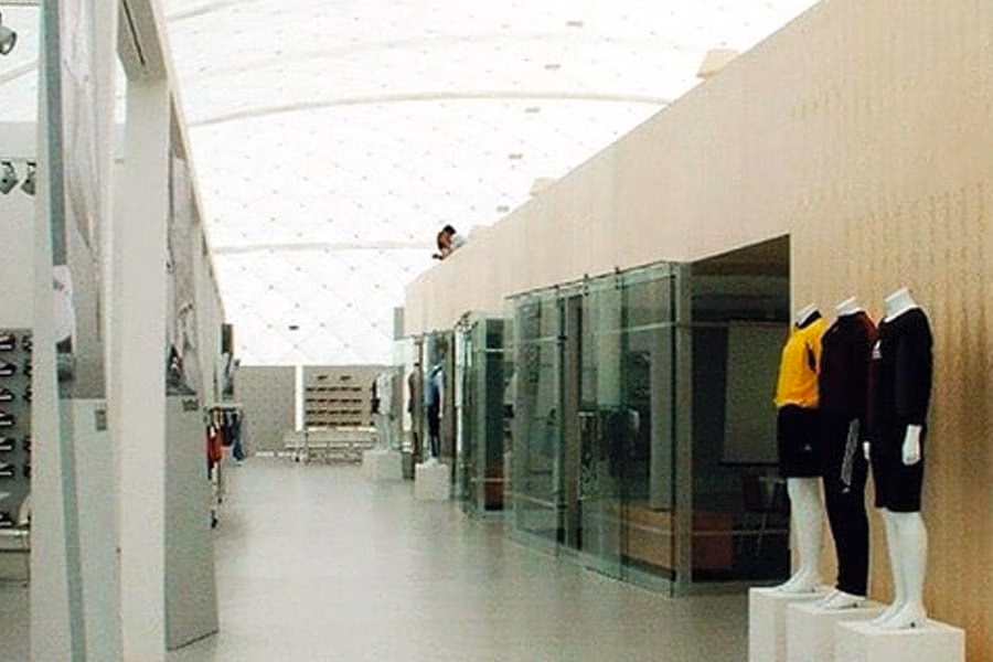 Paranet Nutzungskonzept Messe 1 Heller Verkaufsraum mit Schaufensterpuppen in Sportkleidung unter einem Traglufthallendach.