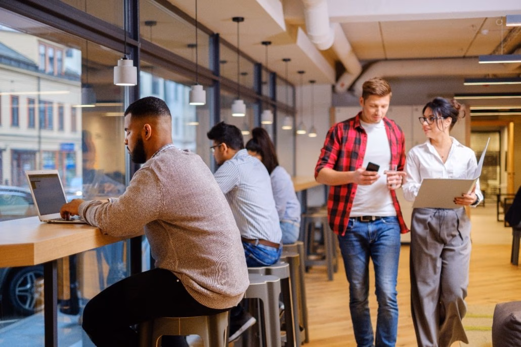 Mehrere Personen sitzen und laufen durch ein Büro