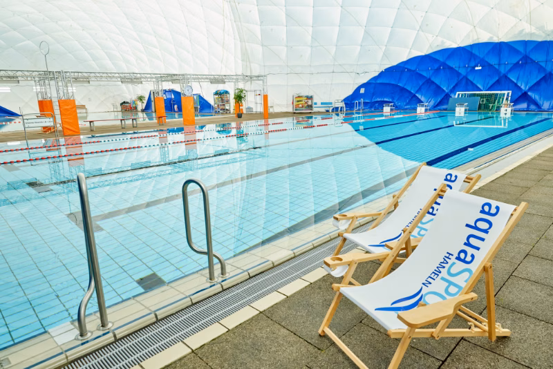PARANET – Traglufthallen als nachhaltige Freibadüberdachungen Zwei Liegestühle am Beckenrand eines Hallenbads in einer PARANET Traglufthalle