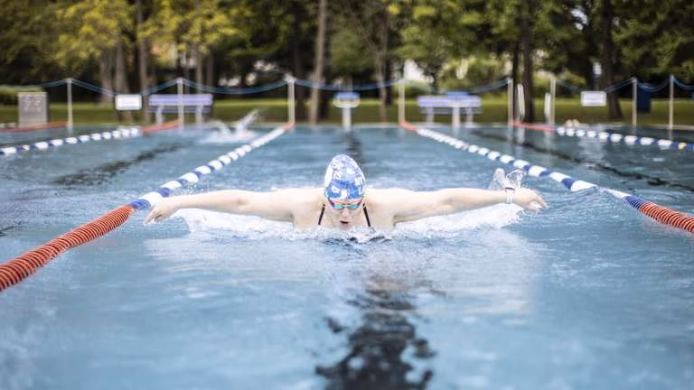 34453512-so-viel-platz-zum-schwimmen-wird-im-hausener-freibad-nicht-immer-sein-in-diesem-sommer-2jT70wEmHj70 Eine Schwimmerin mit blauer Badekappe und Schwimmbrille beim Schmetterlingsschwimmen im Freibad.